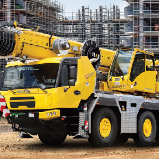 Grove GMK3060L-1 Mobilkran der Firma Bott Abschleppdienst steht vor Baustelle mit Baugerüsten im Hintergrund