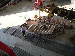 Kran hebt Holzladung auf Baustelle