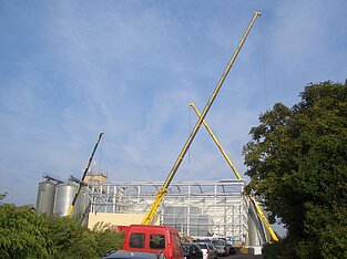 Drei Kräne nebeneinander auf der Baustelle aus der Distanz