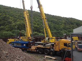 Ladung liegt vor zwei nebeneinander stehenden Kränen auf Baustelle
