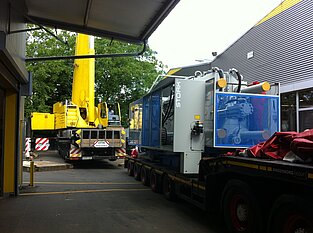 Kran und massive 60t-Maschine bei Verlade- oder Montageeinsatz