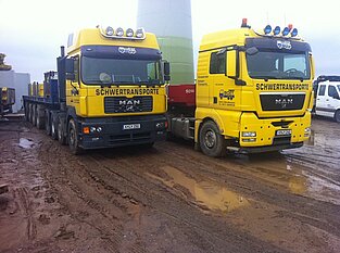 Zwei Schwertransporter nebeneinander auf Windkraftanlagen-Baustelle