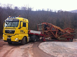 Schwerlasttransporter mit großer Fracht auf anspruchsvoller Straße