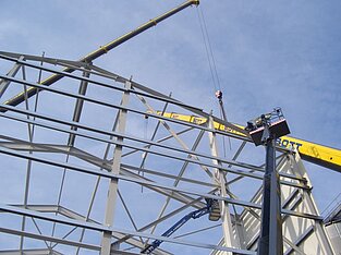 Hallenbau in Arbeit, Kranarm durch das Konstrukt sichtbar
