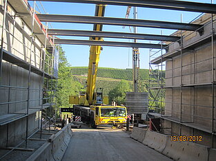 Blick unter der Brücke hindurch auf den Kran auf der anderen Seite