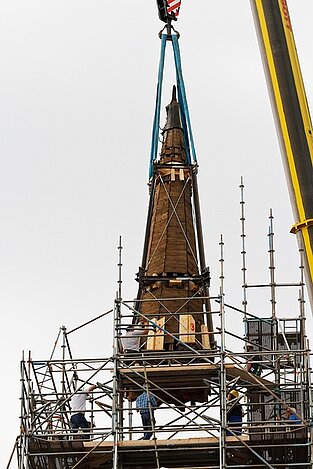 Mobilkran hebt Kirchturmspitze zur finalen Montage